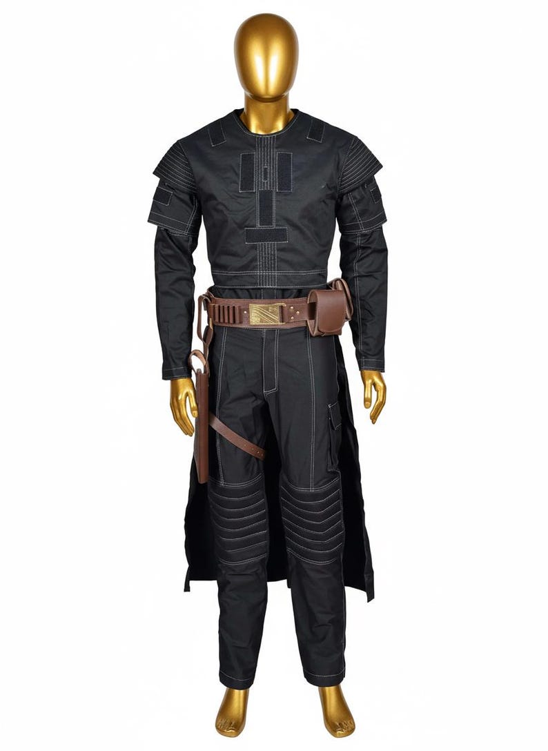 May include: Black costume with white stitching, featuring a long-sleeved top, pants, and a belt with a pouch. The costume includes a long, black cape and brown accessories. The mannequin has a gold head.