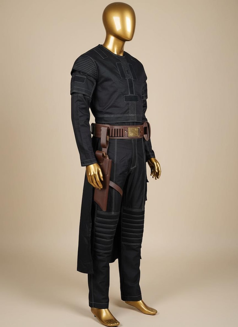 May include: Black costume with white stitching, displayed on a mannequin. The outfit includes a long-sleeved top, pants, and a belt with a holster. The mannequin has a gold-colored head and hands. The costume has a futuristic or sci-fi theme.
