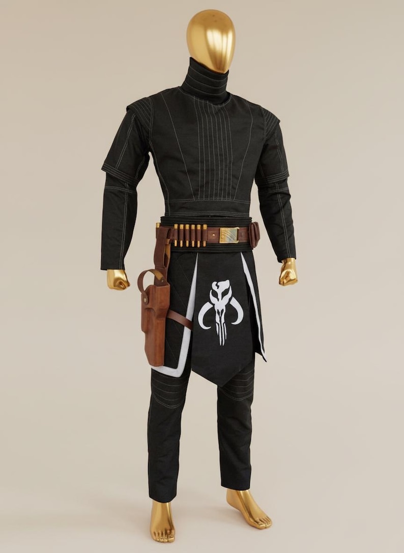May include: A black costume with white stitching, featuring a high collar and long sleeves. The outfit includes a brown belt with ammunition, a holster, and a black apron with a white emblem. The mannequin has a gold head and feet.