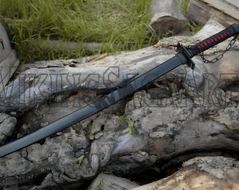 May include: A black katana sword with a red and black handle, lying on a weathered log. The blade is dark, and a chain is attached to the handle. The sword is a traditional Japanese weapon.