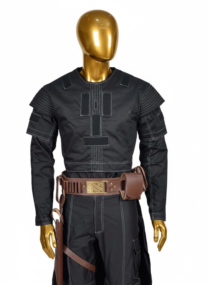 May include: Black costume with white stitching, featuring a long-sleeved top with shoulder accents and a matching pair of pants. A brown leather belt with a gold buckle and a holster with a brown pouch complete the outfit.