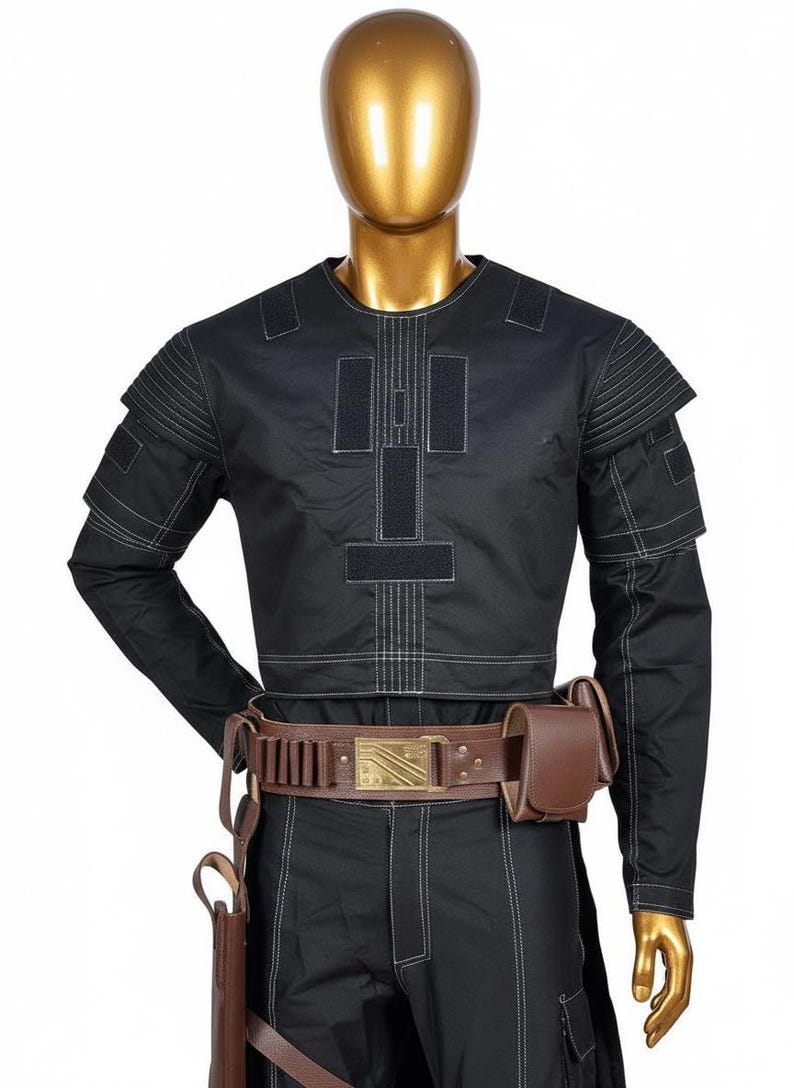 May include: Black costume with white stitching details, displayed on a mannequin. The outfit includes a long-sleeved top, pants, and a brown leather belt with a rectangular buckle. A holster and pouch are also included.