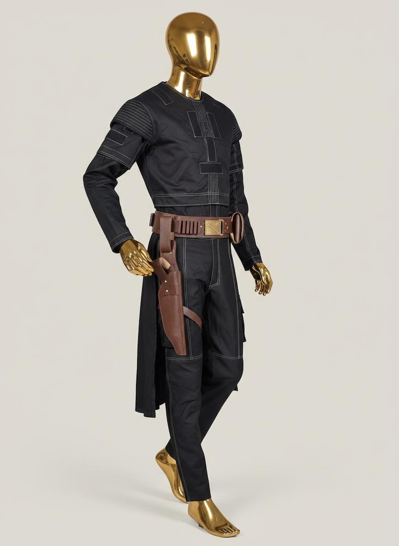 May include: Black costume with white stitching details, displayed on a gold mannequin. The outfit includes a long-sleeved top, pants, and a brown belt with a holster. The mannequin's head and hands are also gold.
