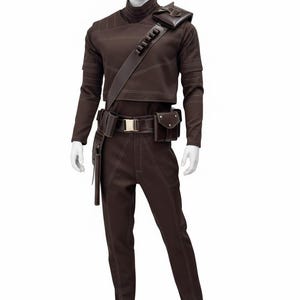 May include: Brown costume with white stitching, displayed on a mannequin. The outfit includes a long-sleeved top, pants, belt, and various pouches. A shoulder strap and a small square pouch are also present. The costume has a futuristic or sci-fi aesthetic.