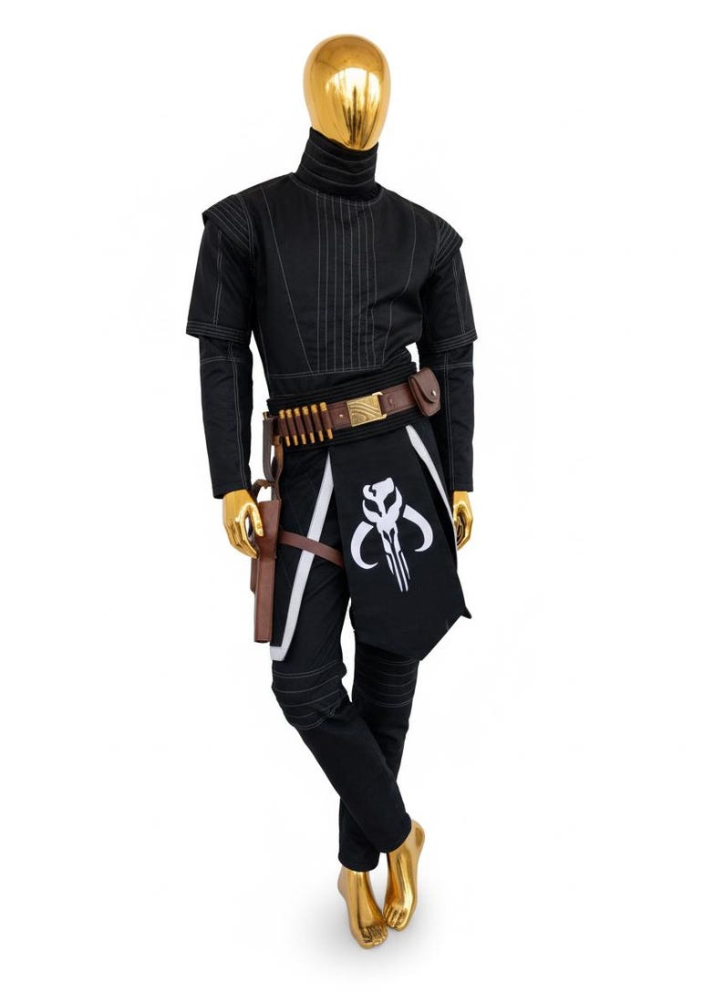 May include: Black costume with a high collar, white stitching, and a brown belt with ammunition. The costume includes a black and white apron with a skull emblem, a holster, and black trousers. The mannequin has a gold head and feet.
