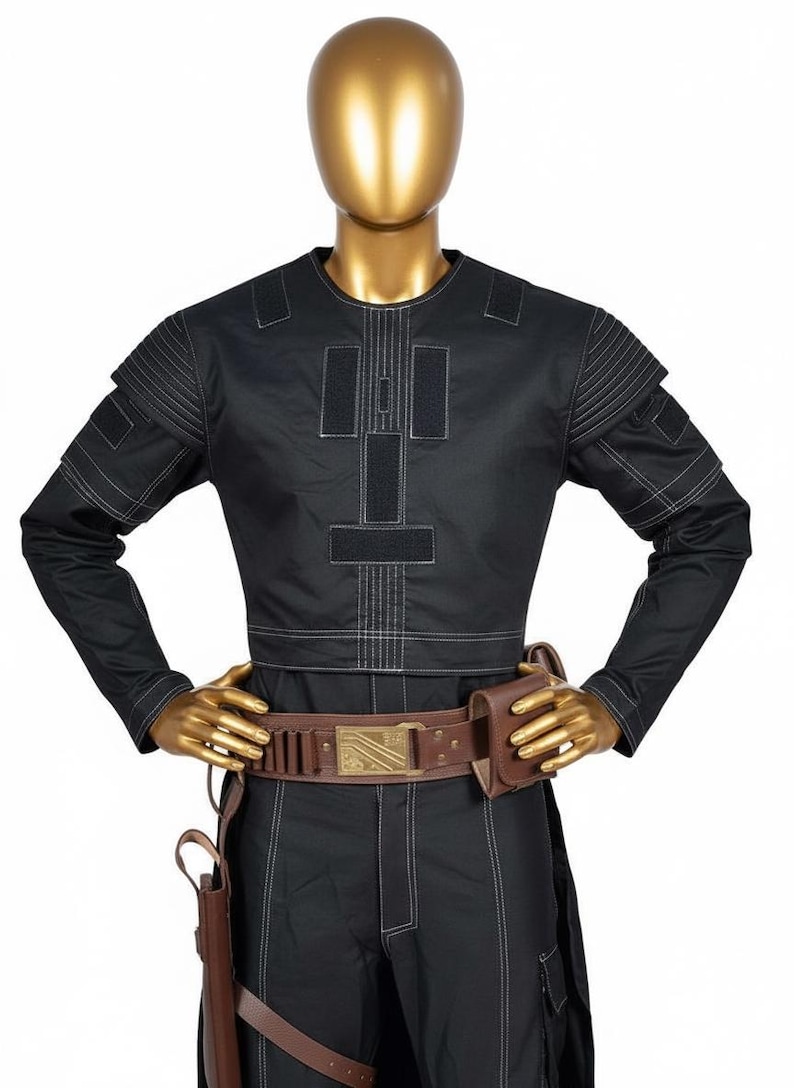 May include: Black jumpsuit with white stitching, featuring a round neck and long sleeves. The costume includes a brown belt with a gold buckle, a holster, and a pouch. The outfit is displayed on a gold mannequin.