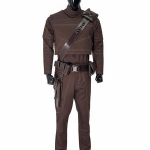 May include: Brown costume with white stitching, featuring a high-collared top, pants, and a utility belt with pouches. A leather shoulder strap and holster are also included. The outfit is displayed on a black mannequin.