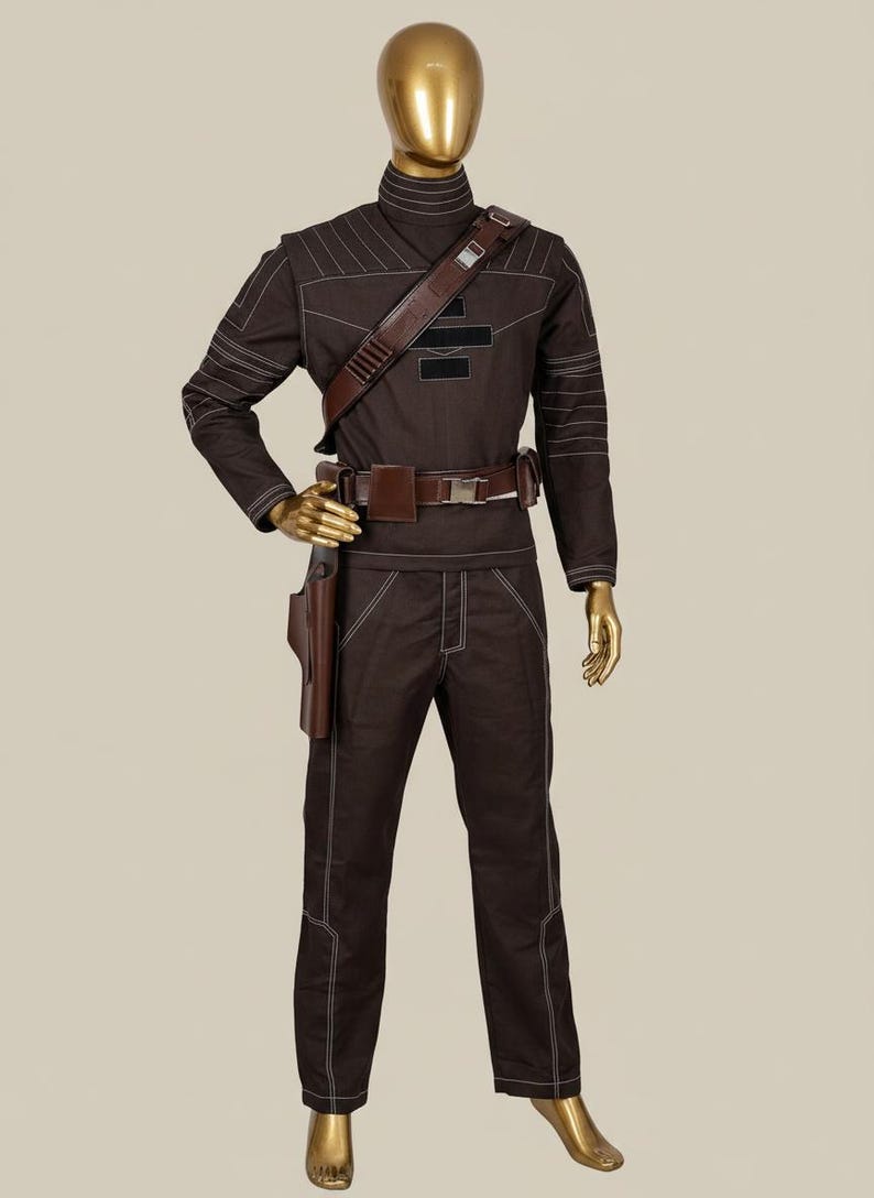 Puede incluir: Un disfraz marr&oacute;n con costuras blancas, exhibido en un maniqu&iacute;. El atuendo incluye una parte superior de manga larga, pantalones y un cintur&oacute;n con una funda. Una correa de hombro marr&oacute;n y un cuello alto completan el look. El disfraz es probablemente para cosplay o un evento tem&aacute;tico.