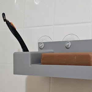 Suction cup soap dish with razor holder