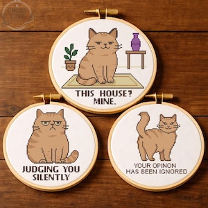 May include: Three round embroidery hoops with cross-stitch cat designs. One says "THIS HOUSE? MINE.", another says "JUDGING YOU SILENTLY", and the last says "YOUR OPINION HAS BEEN IGNORED". Each features a brown cat.