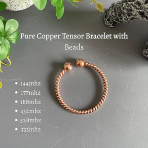 May include: A pure copper tensor bracelet with beads, featuring a twisted metal design and an open-ended circular shape. The text reads: Pure Copper Tensor Bracelet with Beads, 144mhz, 177mhz, 188mhz, 432mhz, 528mhz, 333mhz. The bracelet is metallic copper.