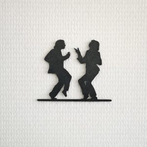 Può includere: Silhouette nera di due persone che ballano, su sfondo bianco strutturato. Le figure sono posizionate su una sottile linea nera, che suggerisce un palco. L'immagine cattura il movimento e la celebrazione.