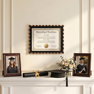 Puede incluir: Un marco de diploma de pared con borde festoneado que contiene un certificado de University of Excellence, flanqueado por dos marcos de fotos de madera oscura con retratos de graduación, un tubo de diploma negro con cinta dorada y un birrete.
