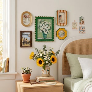 May include: A bedroom scene with a collection of framed art, including a green scalloped frame with a white flower painting. A vase of sunflowers and daisies sits on a wooden nightstand, along with a small potted plant and books. The bed has a woven headboard.