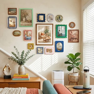 May include: A gallery wall featuring a collection of various rectangular, square, oval, and scalloped picture frames in colors including green, blue, pink, brown, and gold. The frames contain diverse art prints, photographs, and mirrors arranged on a wall.