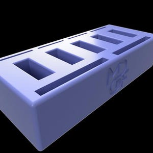 May include: A light blue rectangular object with six rectangular cutouts on top. The object has rounded corners and a logo on the side. The background is black.