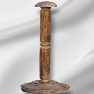 Op de afbeelding: Een houten hoedenstandaard met een ronde basis en een gewelfde bovenkant. De standaard is gemaakt van lichtbruin hout met zichtbare nerf en een klassiek ontwerp. De standaard is ongeveer 30 cm hoog.