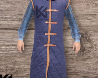 May include: A long, quilted navy blue vest with brown leather straps and trim. The vest has a diamond pattern and a high collar. The logo "KNIGHTS ARMOURY" is visible on the vest.