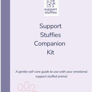 Könnte beinhalten: Ein hellvioletter Buchumschlag mit dem Text "Support Stuffies Companion Kit". Der Umschlag zeigt auch ein Logo mit einem Hund und Pfotenabdrücken sowie den Text "support stuffies". Der untere Teil des Umschlags hat eine Pfotenabdruckgrafik.