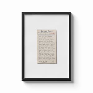 May include: A framed wall art piece featuring a vintage-style beige kitchen check slip with blue and red printed text. The slip contains handwritten black ink notes and the signature A.B. The entire document is centred within a thin black frame.