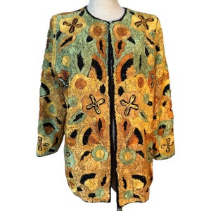 May include: A vintage, open-front jacket with a round neckline. The jacket features intricate embroidery in shades of yellow, orange, green, and black. The floral design is embellished with sequins. The jacket is a unique piece of apparel.