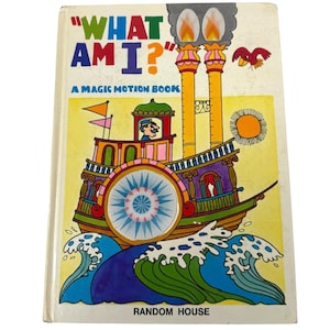 May include: Vintage children's book titled "WHAT AM I?" with a colorful illustration of a steamboat on the cover. The book features a yellow background with blue waves, a sun, and a red bird. The publisher's name, RANDOM HOUSE, is printed at the bottom.