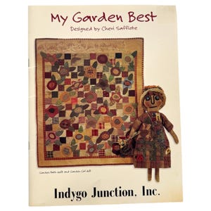 May include: A book cover titled "My Garden Best" by Cheri Saffiote. It features a quilt with floral patterns and a doll in a patchwork dress. The text "Indygo Junction, Inc." is at the bottom.