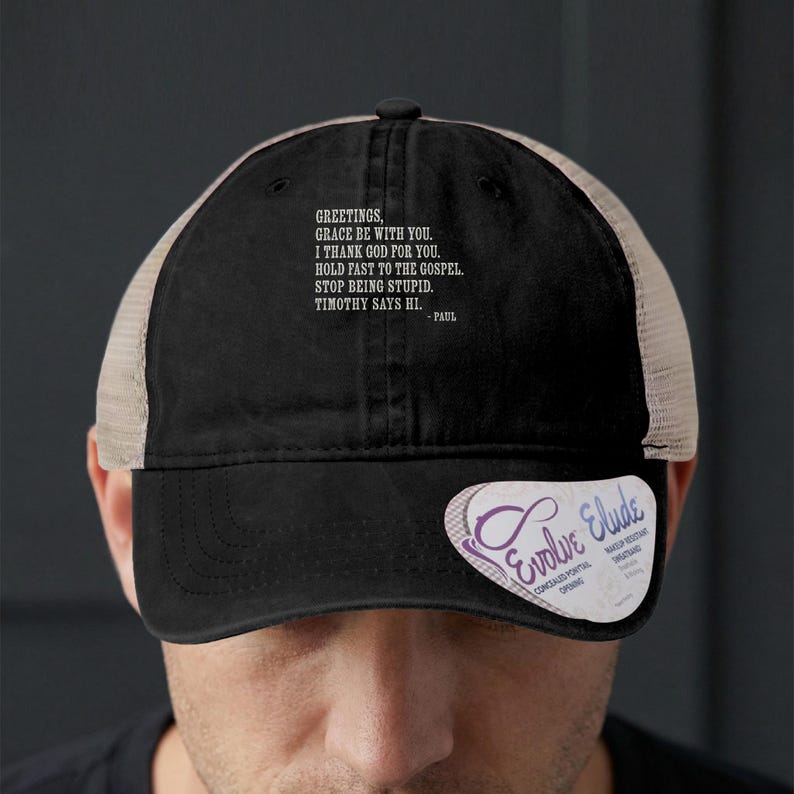 Black trucker hat with quote "Greetings, grace be with you" and "Paul".