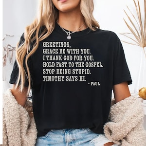 Black t-shirt with white text quoting scripture and Timothy.
