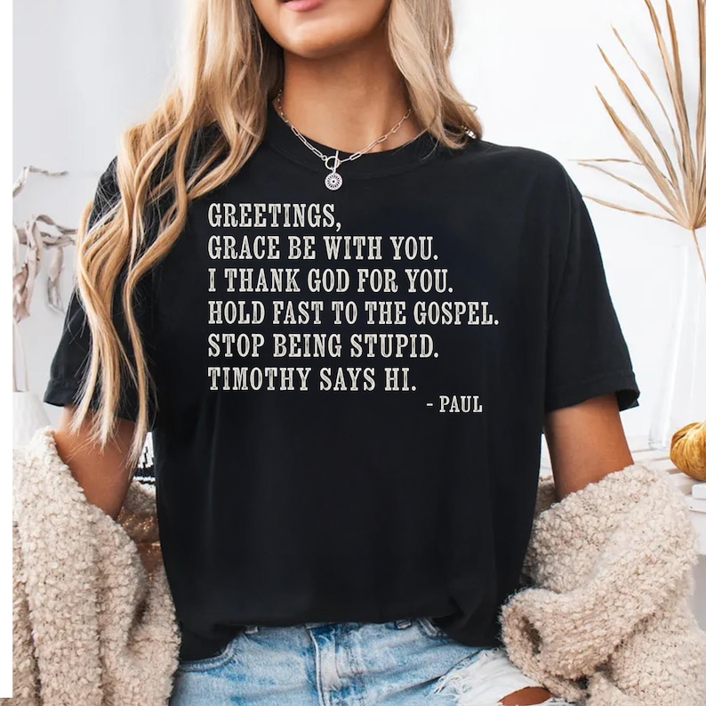 Black t-shirt with white text quoting scripture and Timothy.