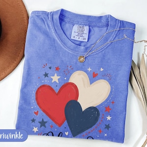 Blue t-shirt with red, white, and dark blue heart graphic and patriotic stars.