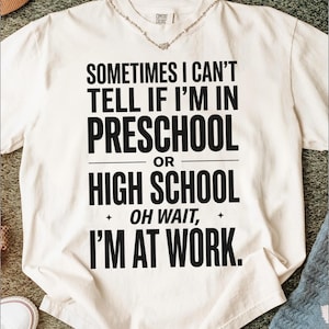 Puede incluir: Una camiseta de manga corta color blanco hueso con texto en negro que dice: SOMETIMES I CAN'T TELL IF I'M IN PRESCHOOL OR HIGH SCHOOL OH WAIT, I'M AT WORK. La prenda tiene cuello redondo y una etiqueta de la marca Comfort Colors en el interior.