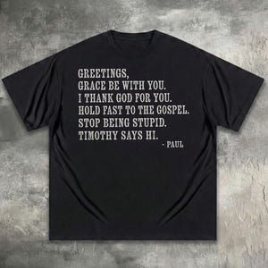 T-shirt with "Greetings, grace be with you. I thank God for you..." text.