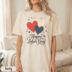 Cream t-shirt with "Happy Labor Day" and red, white, and blue hearts.