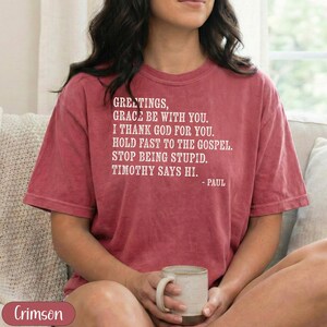 Crimson t-shirt with "Greetings, grace be with you..." text.