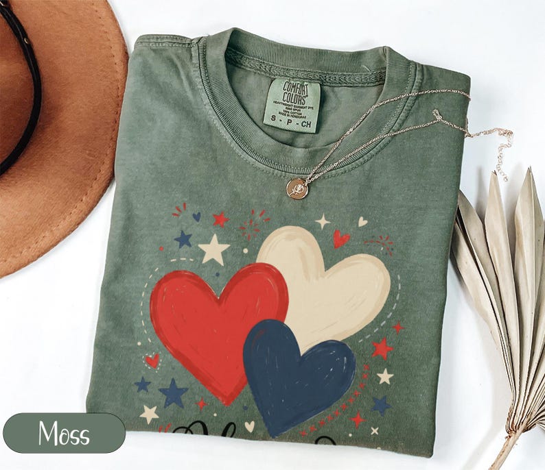 Green t-shirt with red, white, and blue hearts and stars graphic.
