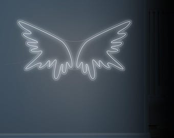 May include: A white neon light shaped like angel wings is mounted on a gray wall. The wings are symmetrical, with a detailed outline. The light is turned on, creating a bright, glowing effect. The wall has a simple, modern design.