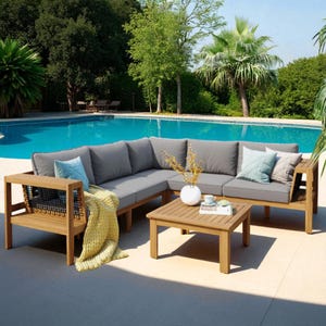 May include: Wooden outdoor sectional sofa with grey cushions and a matching coffee table. Decorative pillows and a yellow blanket are included. The scene is set by a swimming pool and surrounding greenery.