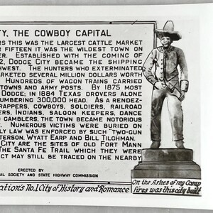 Pode incluir: Postal vintage em preto e branco com texto sobre Dodge City, a Capital do Cowboy, e um desenho de um cowboy. O texto descreve a história da cidade, incluindo seu papel no mercado de gado e a Trilha de Santa Fé.