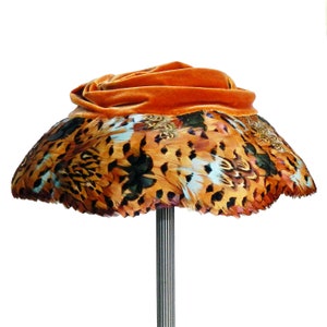 Vintage hoed met verbrande oranje veren