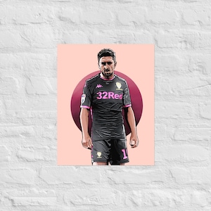 Puede incluir: Ilustración de un futbolista con uniforme negro y rosa con el texto "32Red". El jugador está de pie frente a un círculo rosa sobre un fondo rosa claro. El jugador lleva pantalones cortos negros con el número 1.