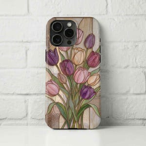 May include: A phone case with a stained-glass effect depicting tulips in purple, pink, and yellow. The floral design is set against a light beige backdrop with a textured look. The case has a glossy finish and a camera module.