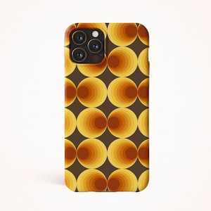 May include: A phone case with a retro design. The case has a dark brown background with a repeating pattern of concentric circles in shades of yellow, orange, and brown. The phone's camera lenses are visible at the top.