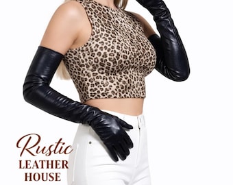 May include: Black leather opera gloves. The gloves extend past the elbows. The image also shows a leopard print top and white pants. The text "Rustic Leather House" is in the lower left corner.