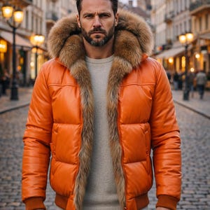 May include: An orange puffer jacket with a fur-lined hood and trim. The jacket has a bomber-style design with a ribbed hem and cuffs. The person is wearing a gray sweater underneath. The jacket is made of a shiny material.