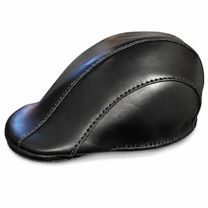 May include: A black leather newsboy cap with a rounded crown and a small, stiff brim. The cap is made of smooth, shiny leather and features visible stitching along the seams. The hat is designed to be worn on the head.