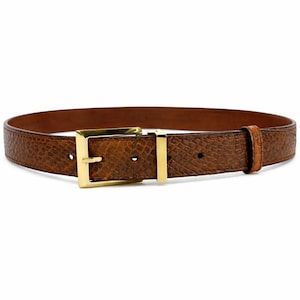 May include: A brown leather belt with a textured snakeskin pattern. The belt features a gold-colored rectangular buckle and a matching belt loop. The belt is a classic accessory.