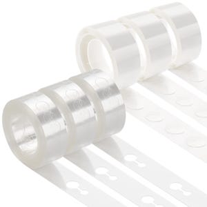 May include: Six rolls of clear adhesive tape arranged in two rows. Each roll features a series of circular, pre-cut adhesive tabs attached to a continuous backing strip. The tape is transparent, and the circular tabs are clearly visible on the rolls.