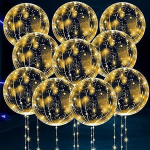 May include: A cluster of eleven clear, spherical decorative lights, each filled with warm, golden fairy lights. The spheres are suspended from thin, star-shaped light strands, creating a festive and illuminated display. Ideal for holiday or event decor.
