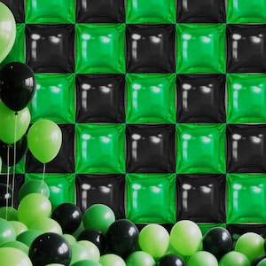 May include: A festive scene with a backdrop of alternating green and black square balloons. A cluster of green and black balloons are scattered on the floor, with some floating in the air. The balloons create a celebratory atmosphere.